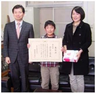 小学校でお母さんと受賞する伊与田君(中央)